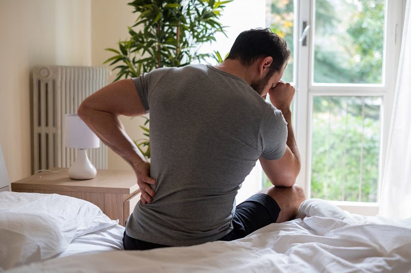 Man in pain holding back